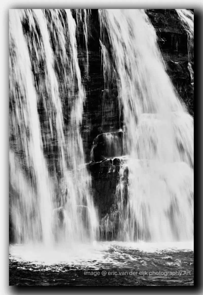 Zwart-wit abstract natuurbeeld van een waterval met subtiele contrasten