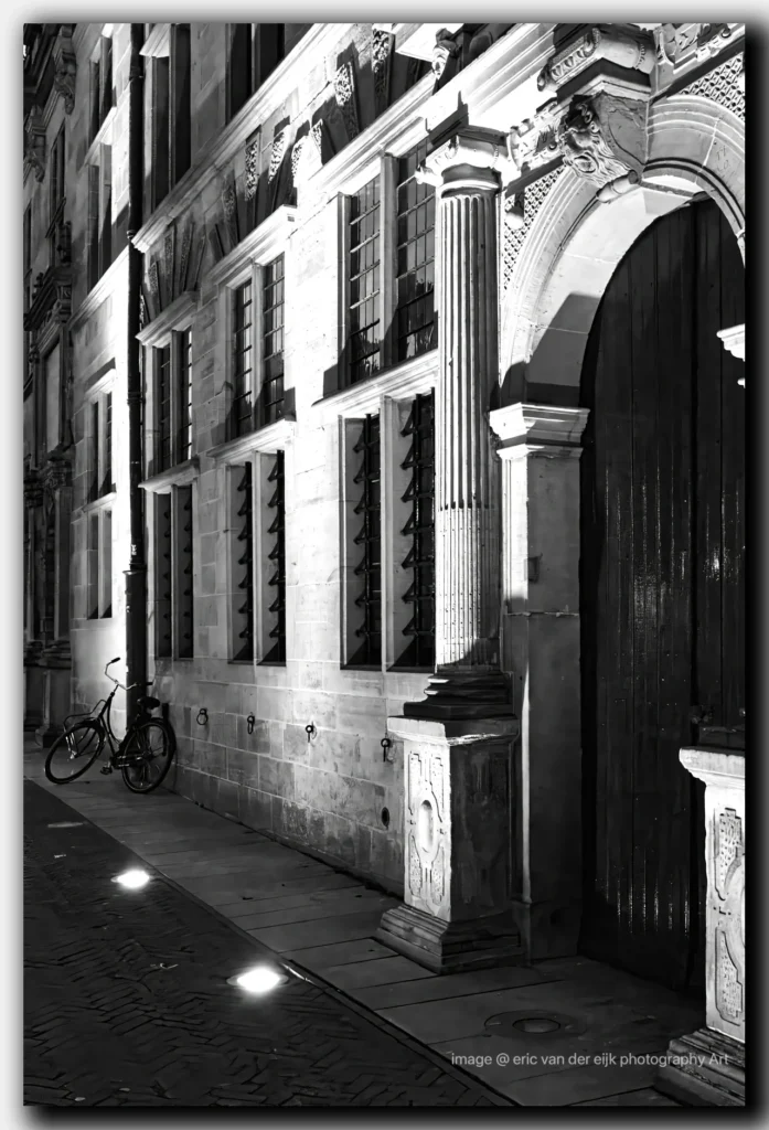 Zwart-wit foto van de gevel van het Stadhuis van Leiden met een damesfiets