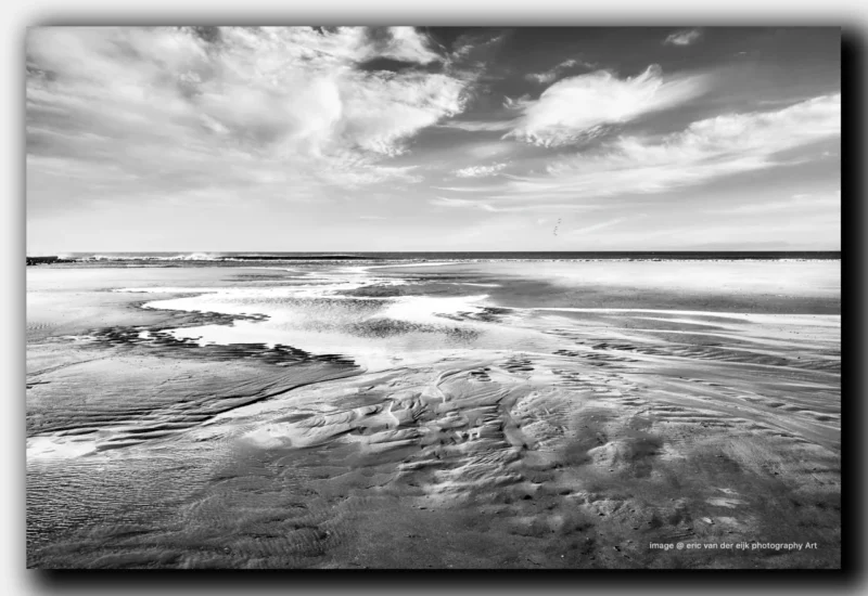Het strand de Noordzee met getijdenwerking zwart wit